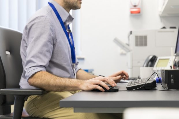 Close up of a male doctor working at a computer