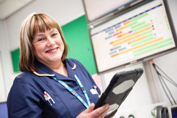 A theatre nurse using a tablet device