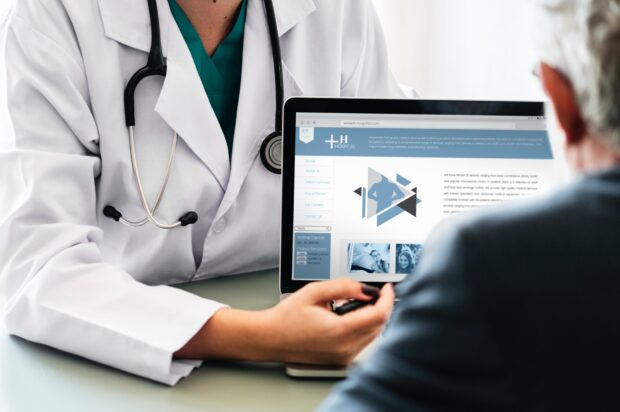 A doctor pointing at the screen of a laptop