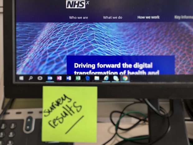 A screen with a picture of the NHSX website and post it note which has "survey results" written on it