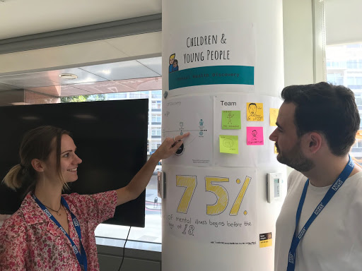 Two people looking at posters about children and young people's mental health services