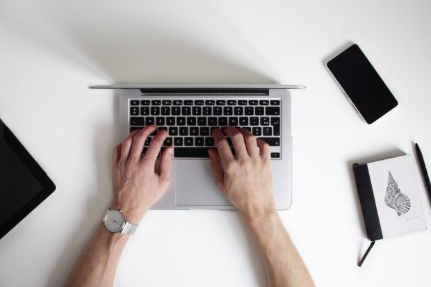 A photo of someone typing on a laptop.